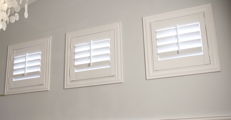 White shutters on small windows in laundry room